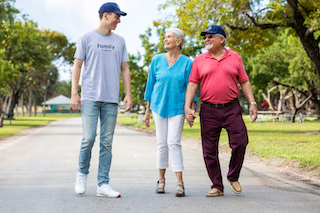 Papa Pal walking with an elderly couple to help them stay physically active.