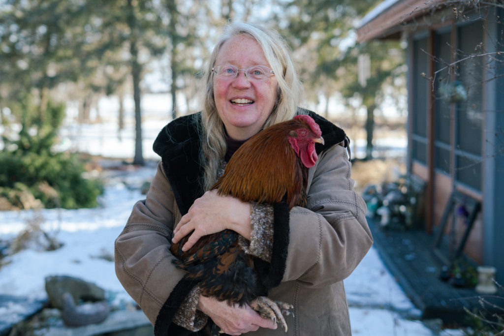 Papa member Claudette holding her pet chicken in her backyard