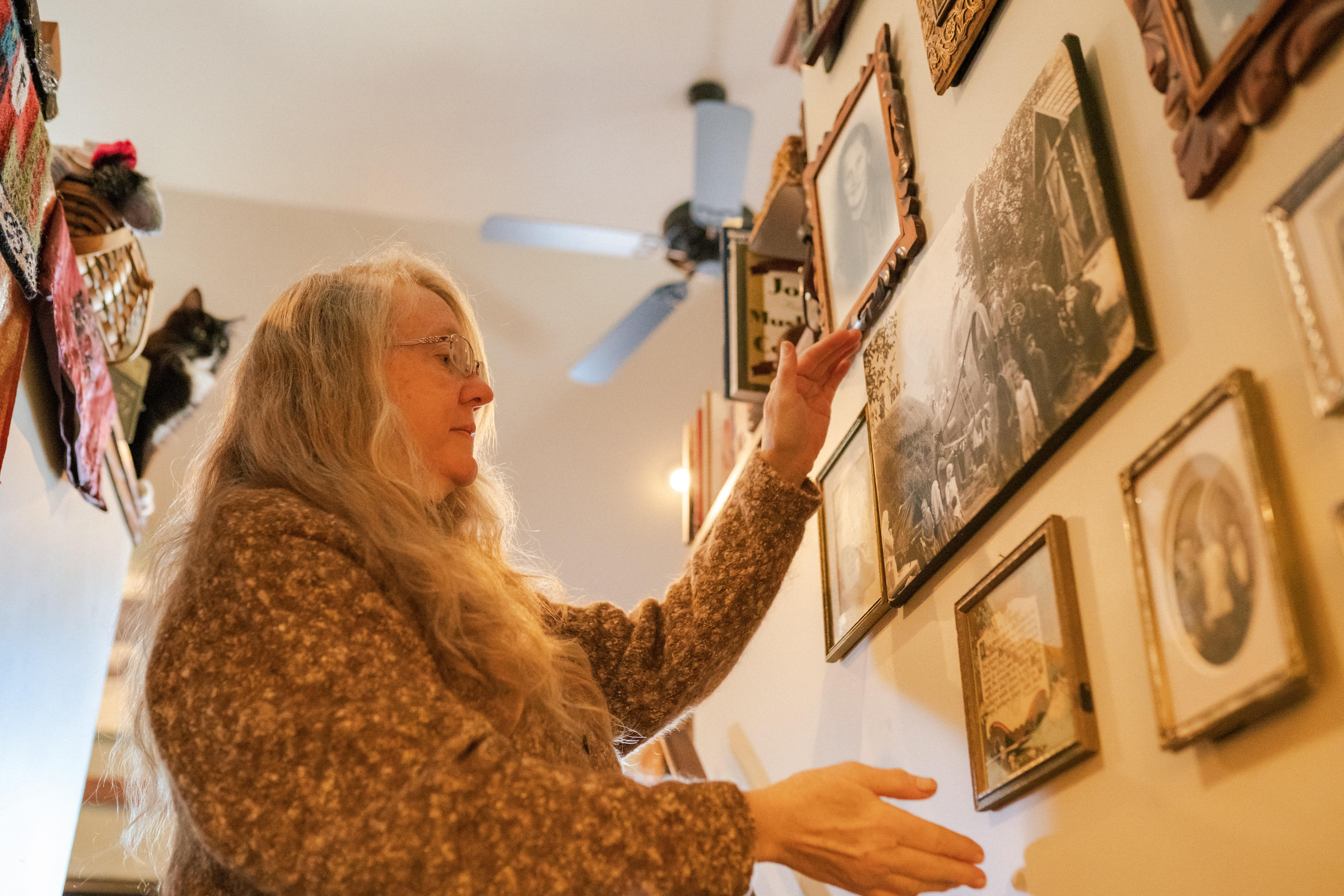Papa member, Ingrid showing pictures of her family members on the wall