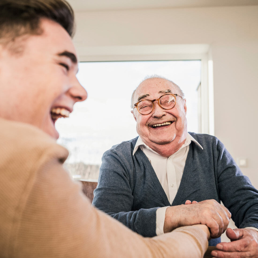 Elderly man and his young companion laughing and enjoying each other's company