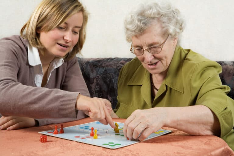 An elderly woman and her Papa Pal playing Ludo together. This board game can help can keep the brain condition at its peak and stay healthy.