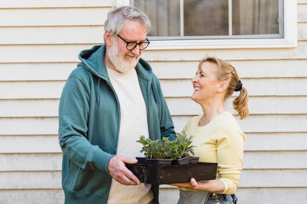 A caregiver assisting an older adult with household tasks.