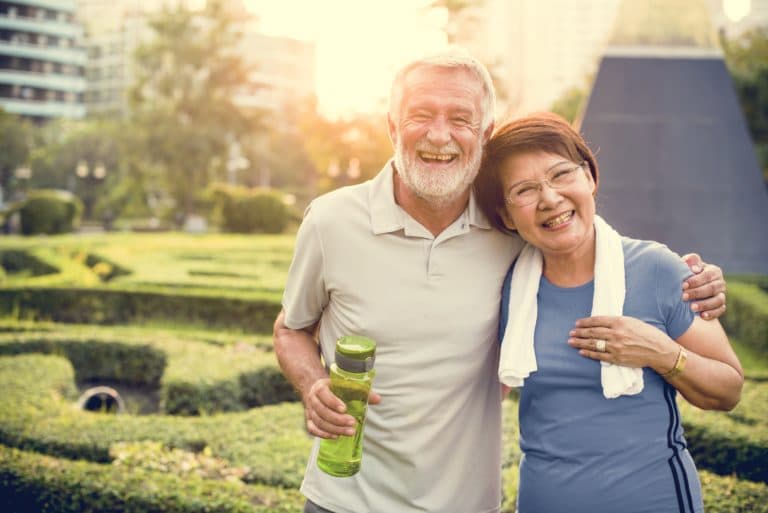 Elderly couple smiling and looking content after a great workout together