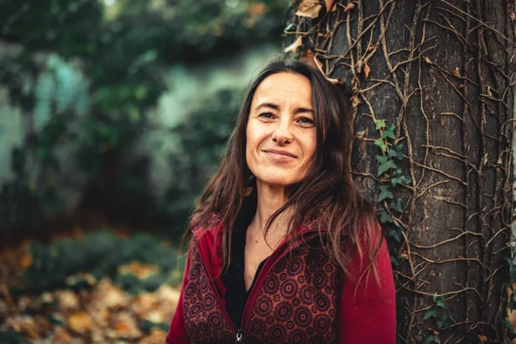 Smiling woman leaning against a tree thinking of the best gig jobs.