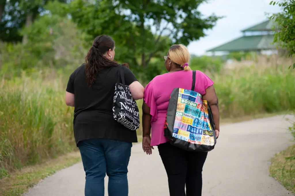 Michelle and Felicia walking away with their backs turned to the camera.