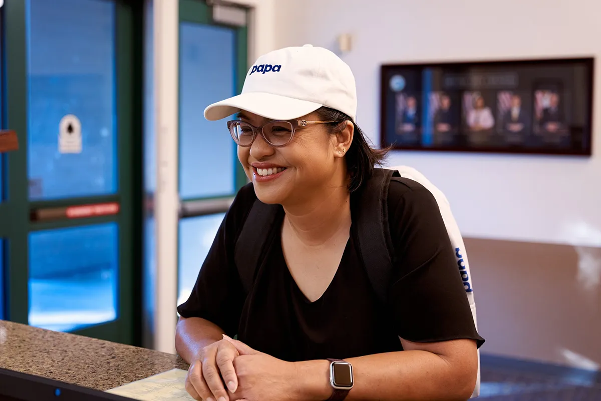 Smiling woman wearing a white Papa hat.