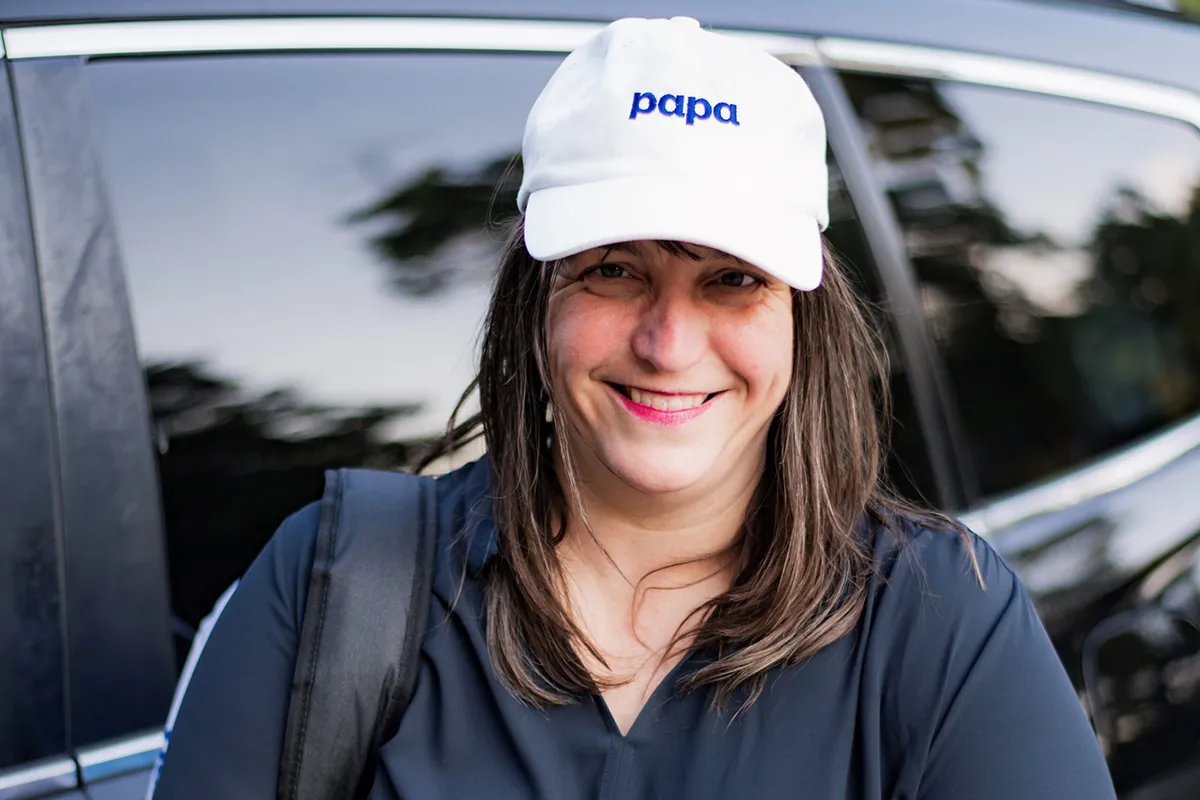 Close-up of a smiling woman wearing a Papa hat.