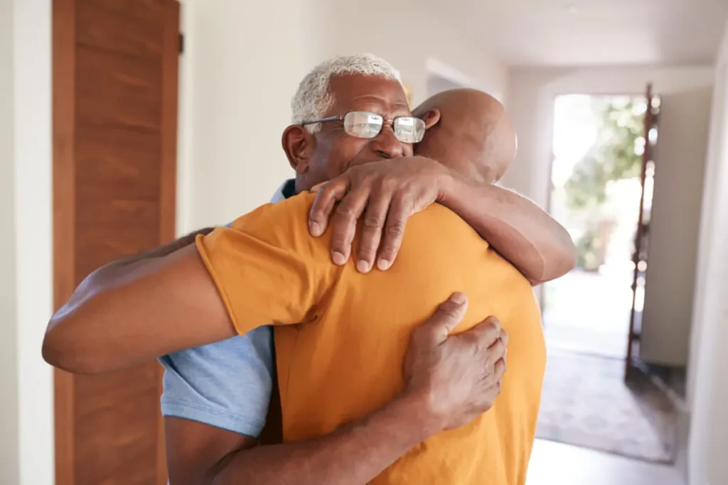 Father and son hugging during a successful social isolation care plan.