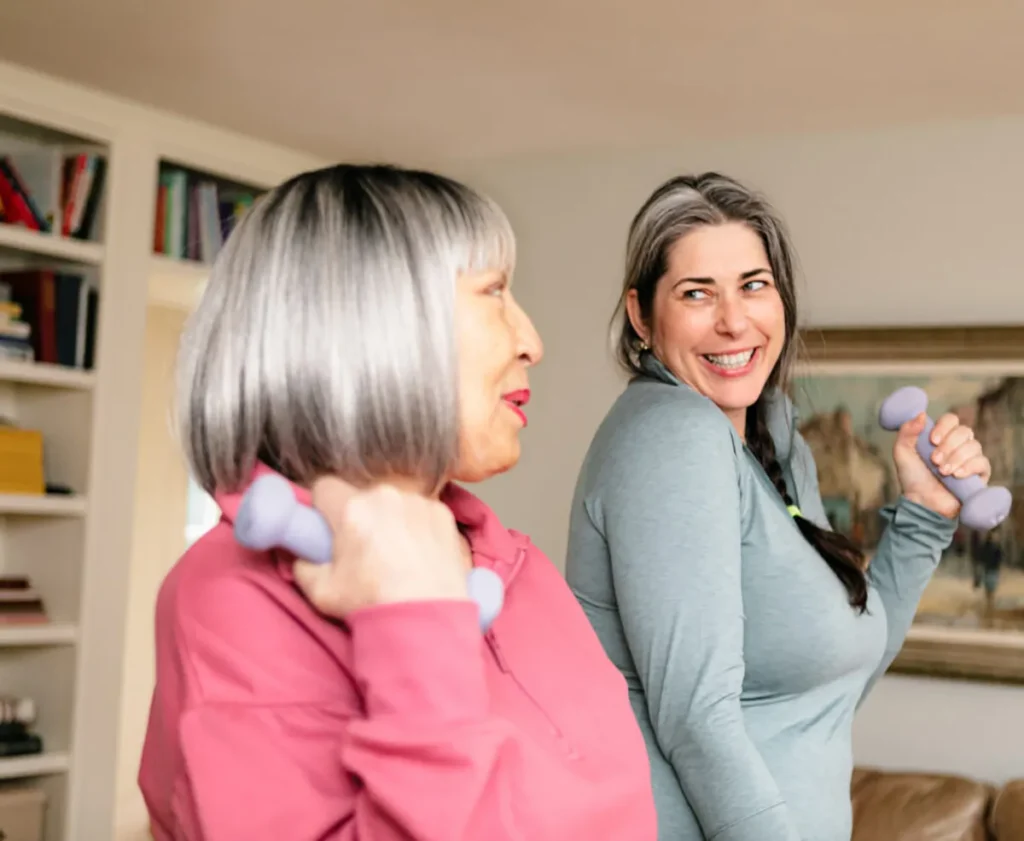 Two elderly women exercising at home.