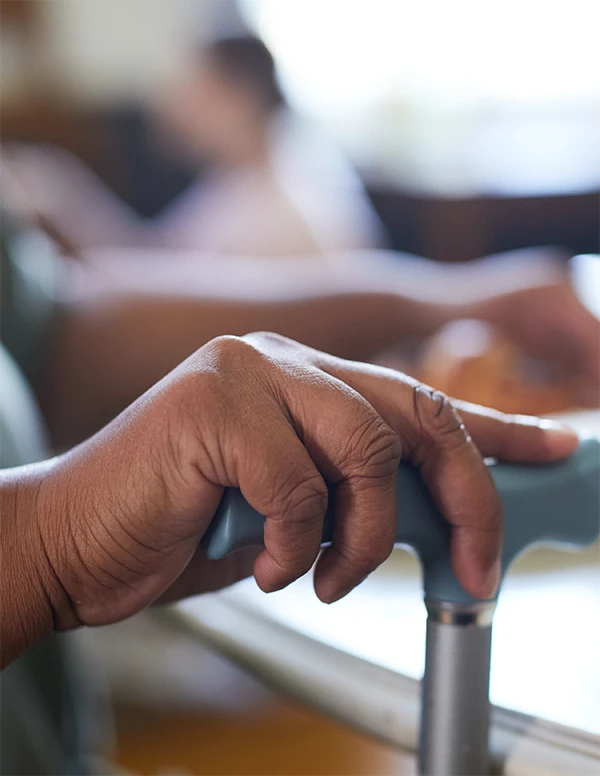 Hand holding a walking cane.