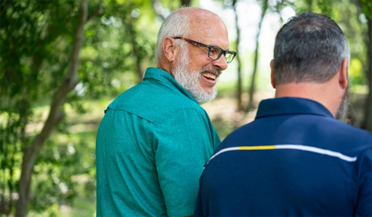 Two men walking together engaged in conversation.