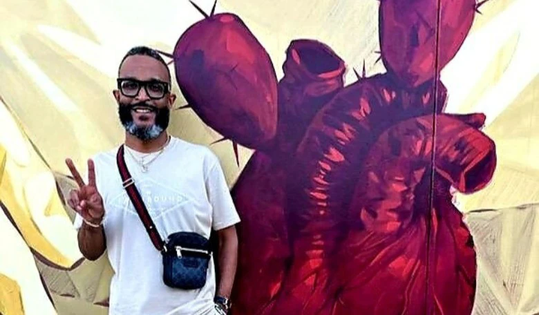 Man in front of heart painting.