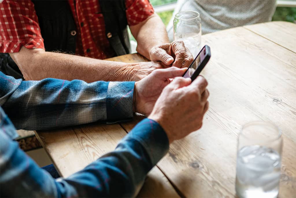 Companion caregiver showing a member how to use their mobile device.