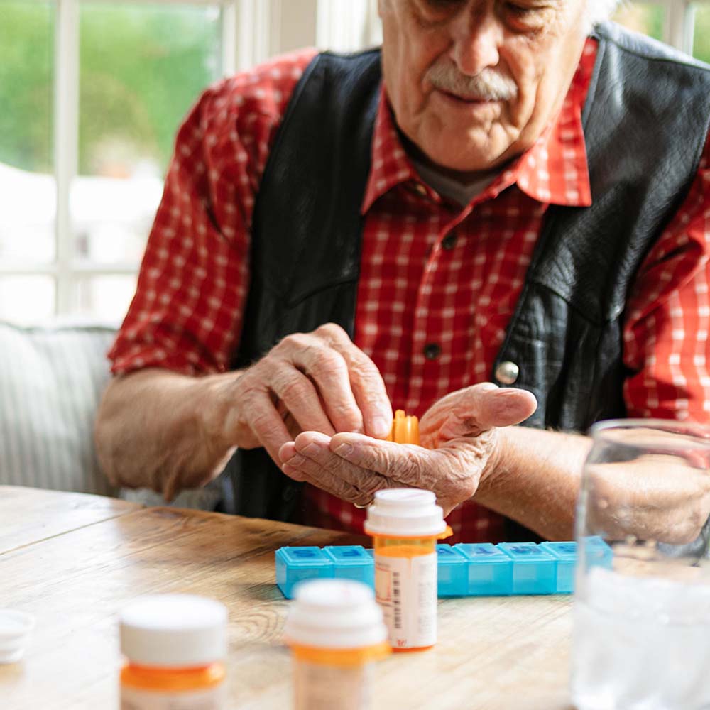 An elderly Papa member, taking his medication.